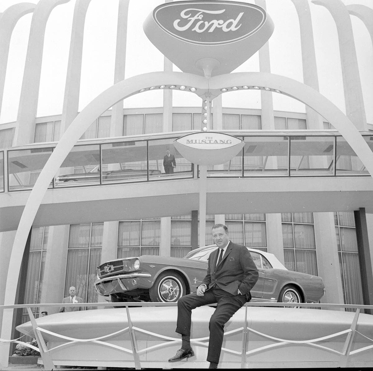 El Ford Mustang Ford Mustang hizo su debut público en carrocerías techo duro y convertible, en la Feria Mundial de Nueva York de 1964. En la imagen se ve a Henry Ford II posando junto al nuevo auto en el pabellón Ford. Aunque el Mustang llegó en la primavera de 1964, la compañía lo promocionó desde el principio como un modelo 1965.