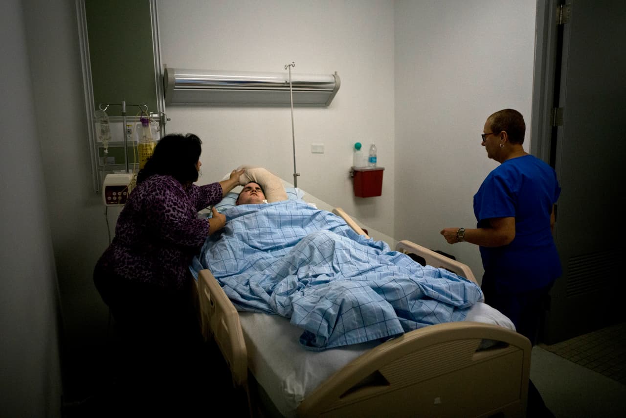 Damaris Torres vigila a su hijo Manuel Alejandro Olivencia en el hospital de Cataño, Puerto Rico. Días antes de la llegada del huracán, Torres trató de encontrar un lugar seguro para su hijo, que ha estado en cama durante una década después de un accidente de tráfico y depende de un ventilador, tanque de oxígeno y un tubo de alimentación.