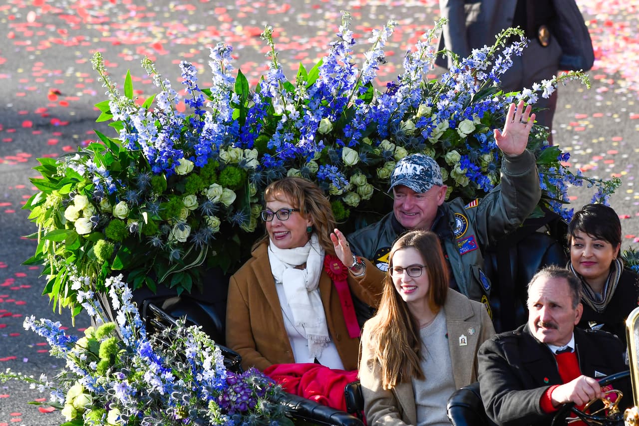 La excongresista Gabby Giffords saluda desde su carroza acompañada por su esposo el senador de EEUU por Arizona, Mark Kelly.