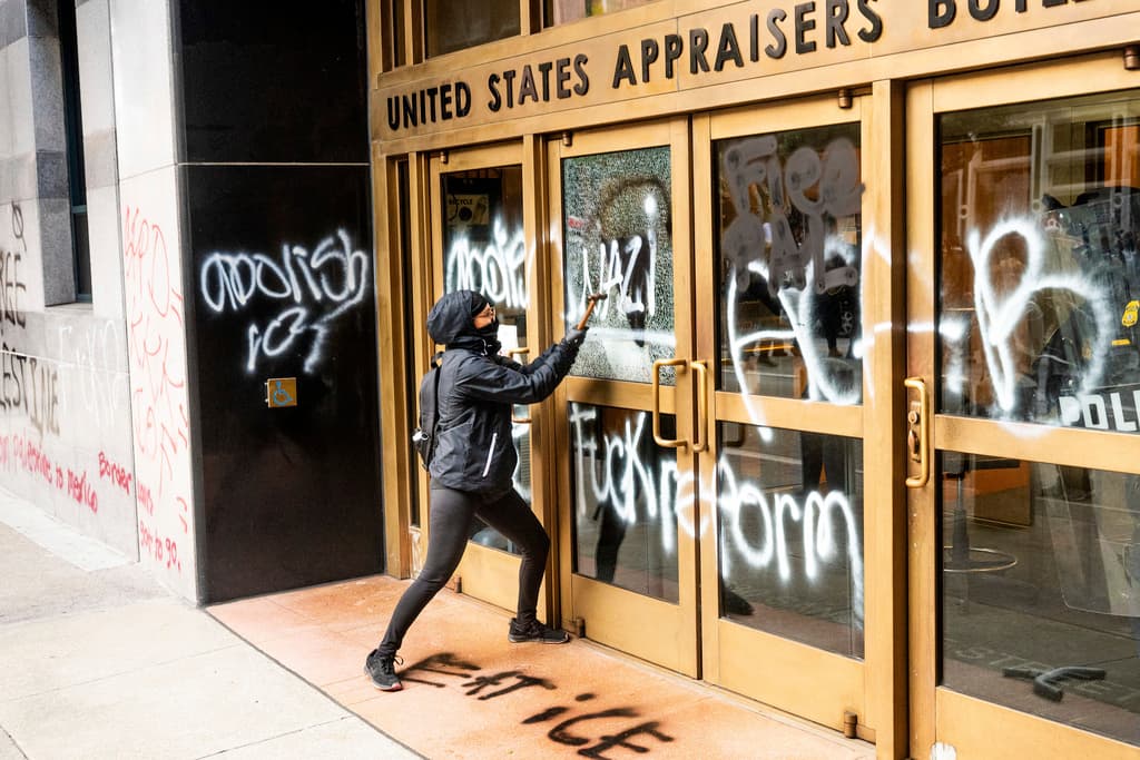 Un manifestante rompe un cristal del edificio de ICE en San Francisco el domingo 8 de junio.