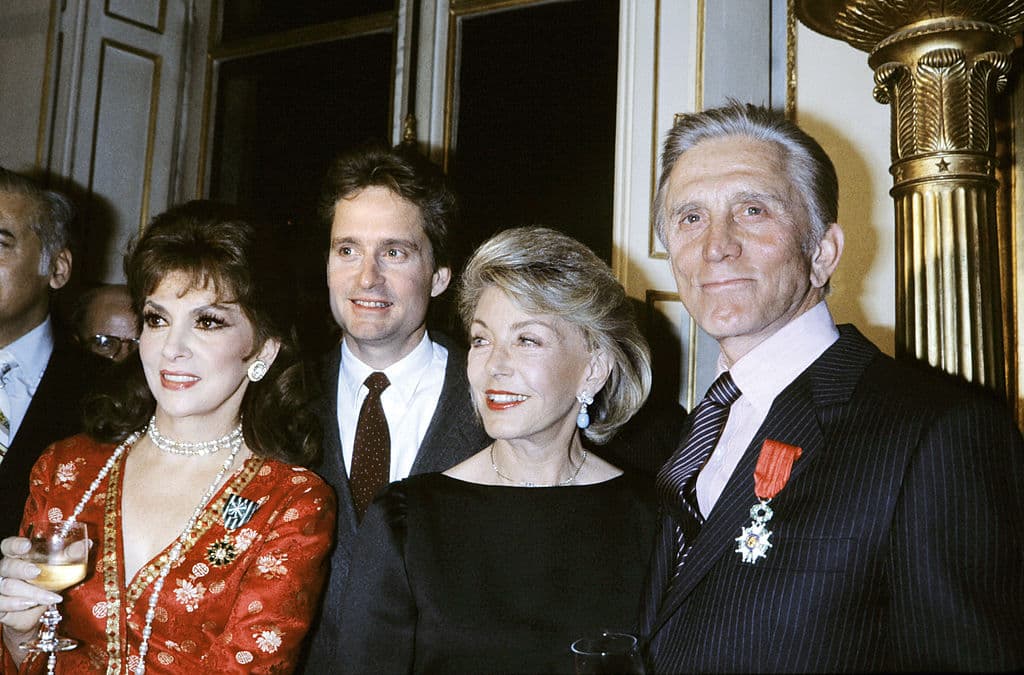 US actor Kirk Douglas (R) poses next to his wife Anne (2nd R), and his son actor Michael Douglas (2nd L) after being awarded Chevalier of the French Legion d'Honneur, on March 01, 1985 in Paris. At right, Italian actress Gina Lollobrigida was awarded Officer of the Order of Arts and Letters. AFP PHOTO GEORGES BENDRIHEM (Photo credit should read GEORGES BENDRIHEM/AFP/Getty Images)