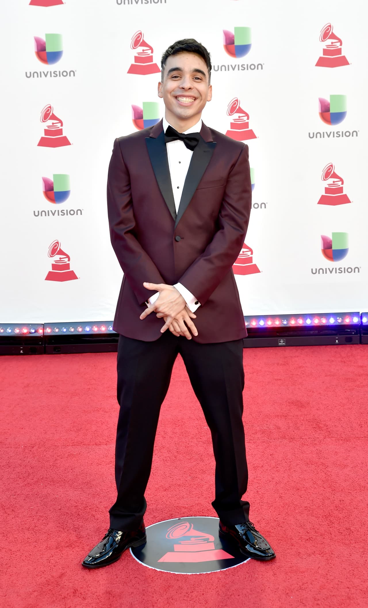 El rapero mexicano Mc Davo se olvidó de su estilo urbano, aunque sea por esta noche, y se puso de gala. Además le agregó un toque especial a su look con su saco en color vino.