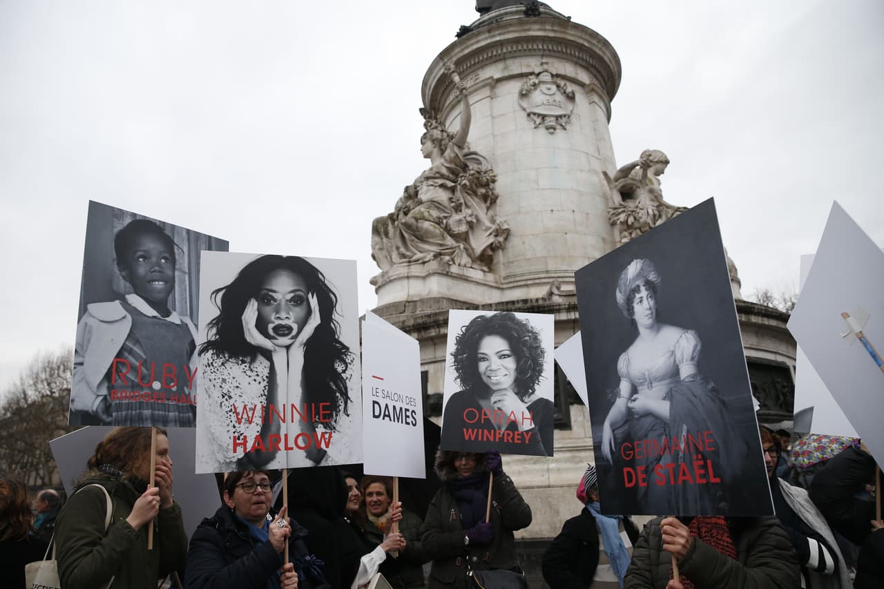 <b>Francia.</b> Retratos de diferentes mujeres destacadas son sostenidas por las activistas que manifiestan por el Día Internacional de la Mujer en la Plaza de la República de París.