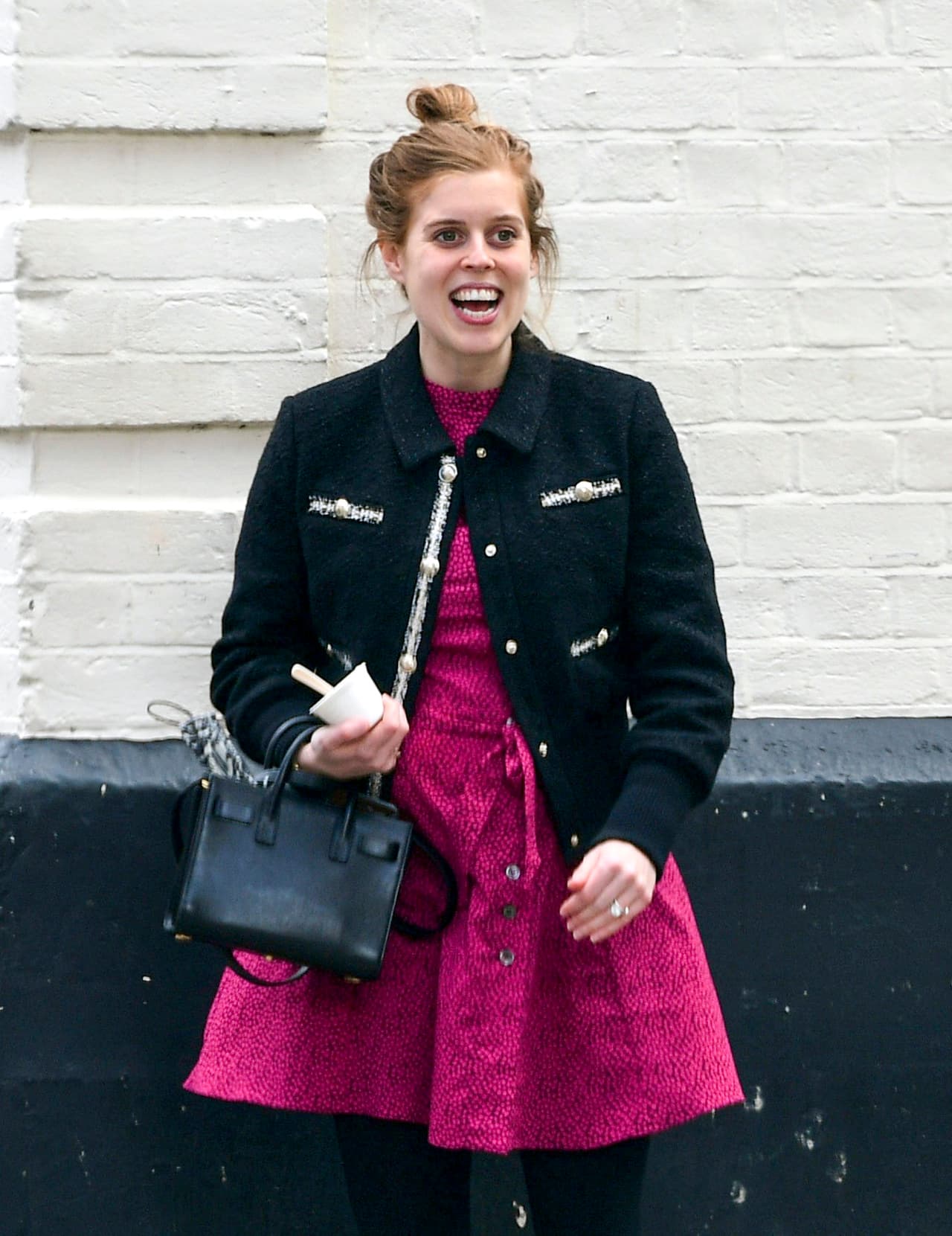 El look lo combinó con una chaqueta negra ajustada, medias y botines y un pequeño bolso negro. 
<br>