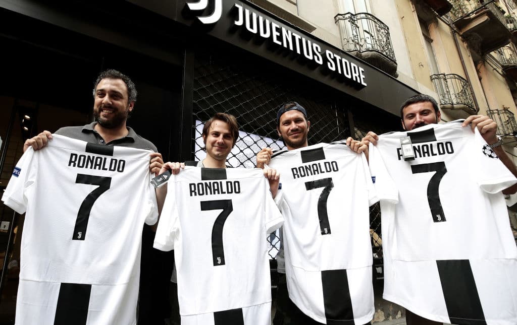 Los aficionados de la Juventus posan felices con su compra, la playera oficial de Cristiano Ronaldo.