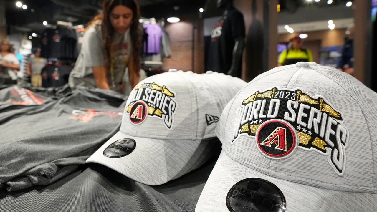 Un empleado de la tienda de los Arizona Diamondbacks en el estadio Chase Field reabastece gorras de béisbol de la Serie Mundial de los Diamondbacks el miércoles 25 de octubre de 2023 en Phoenix.
