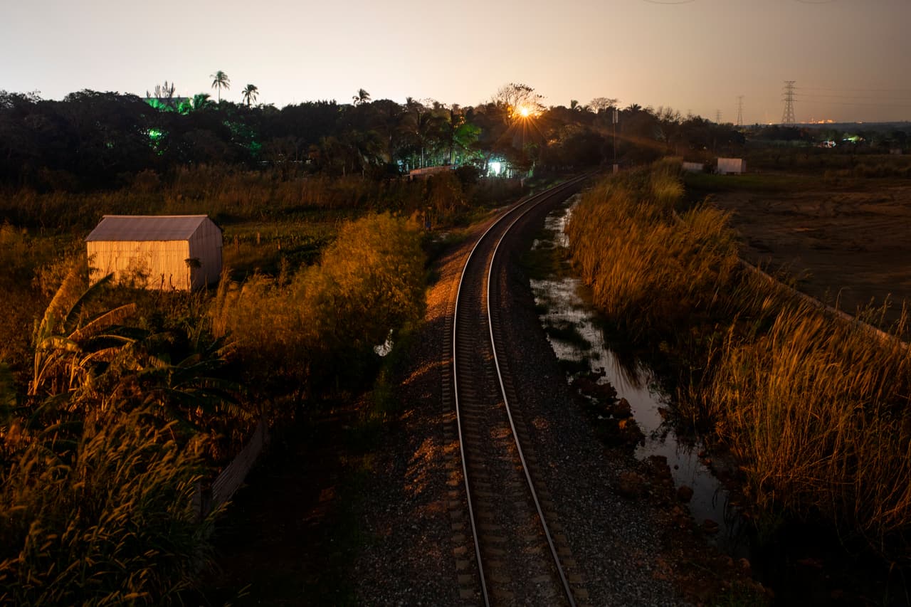 En esta foto del 21 de noviembre de 2019, el sol se pone en Coatzacoalcos, en el estado de Veracruz, donde los migrantes abordan trenes que viajan el norte. Coatzacoalcos es un cuello de botella para el tráfico de personas que vienen del sur de México y donde las autoridades han enfocado sus esfuerzos para combatirlo. (AP Foto/Félix Márquez)