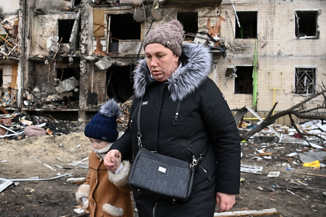 Contradiciendo la información oficial de Ucrania, en su primer informe sobre bajas militares, Rusia dijo que 498 soldados rusos han muerto en la operación, y 1,597 han resultado heridos. La fotografía muestra a una mujer y un niño caminando frente a un edificio de apartamentos bombardeado en Koshytsa, un suburbio de Kiev.
<br>