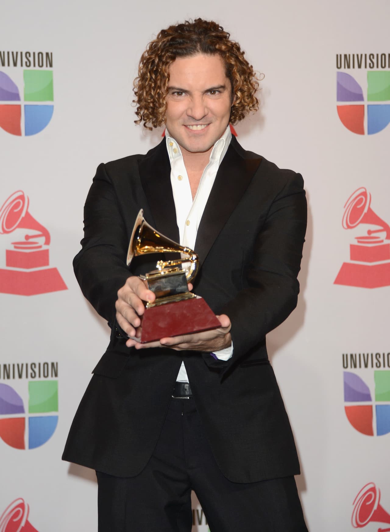 El año anterior, David Bisbal lució una combinación de negro y blanco en un traje con camisa, sin corbata. Así celebró su galardón por Mejor Álbum Pop Tradicional.