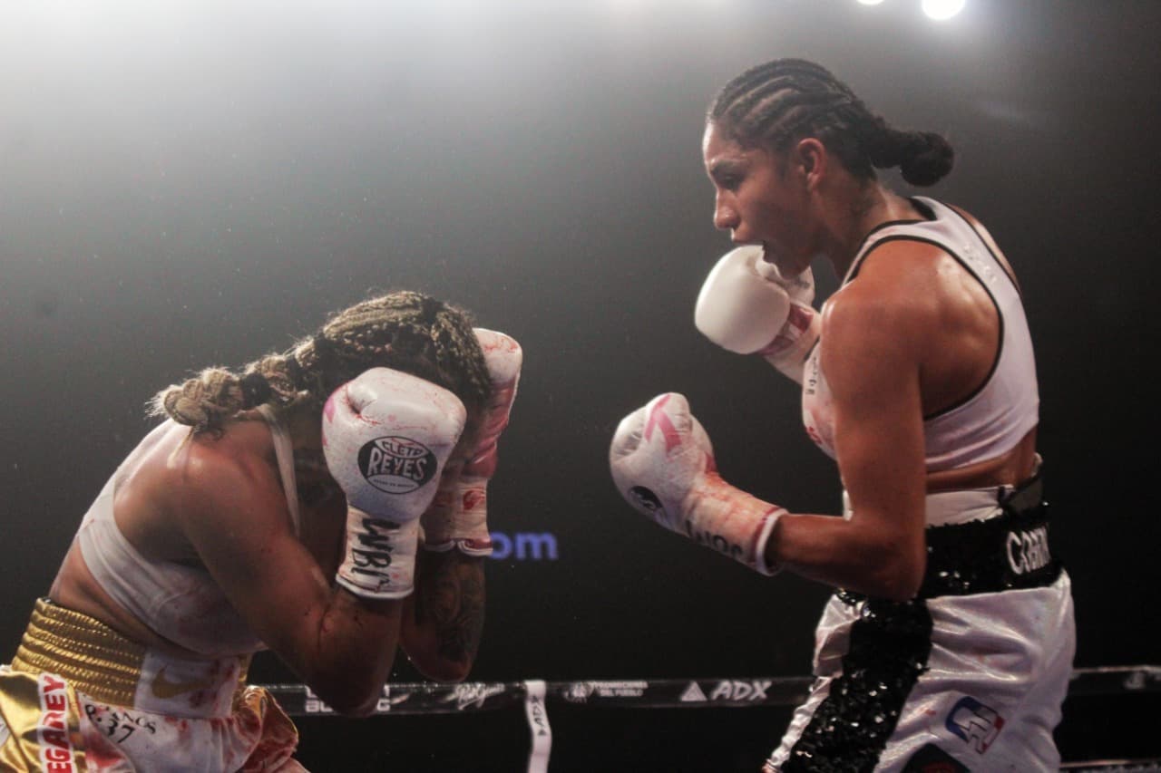 Mariana ‘Barby’ Juárez fue castigada desde el primer asalto con veloces y certeros golpes. Al final de la pelea, la esquina de Juárez pidió que se revisaran los guantes de Luna; tras no encontrar irregularidades, 'Cobrita' se coronó como campeona Gallo del Consejo Mundial de Boxeo.