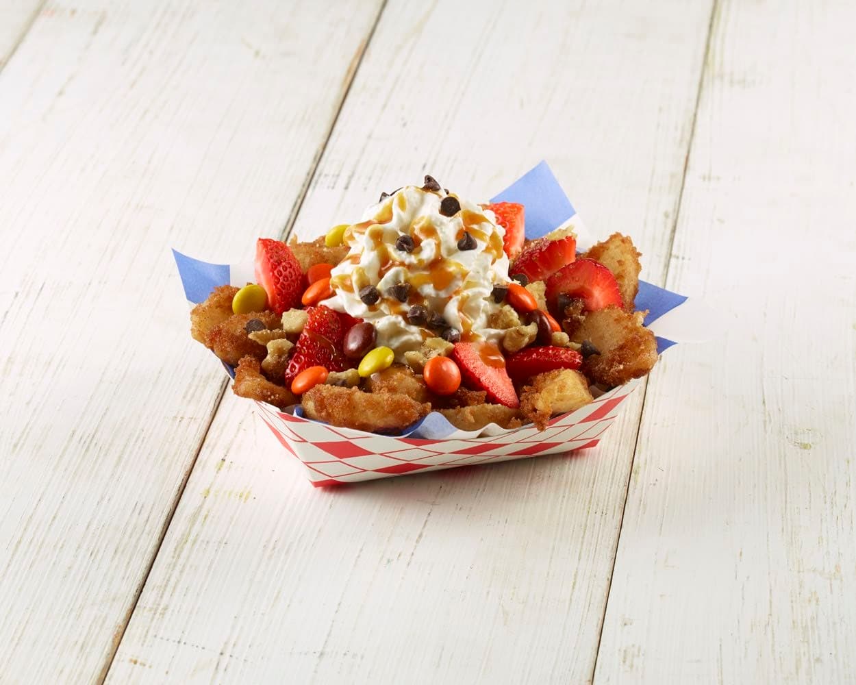 DEEP FRIED BAYOU FRUIT BITES - Este postre se produce utilizando gajos de fruta fresca fritos y cubiertos con un dulce. Se termina con una cobertura batida cremosa y se rocía con salsa de caramelo caliente.