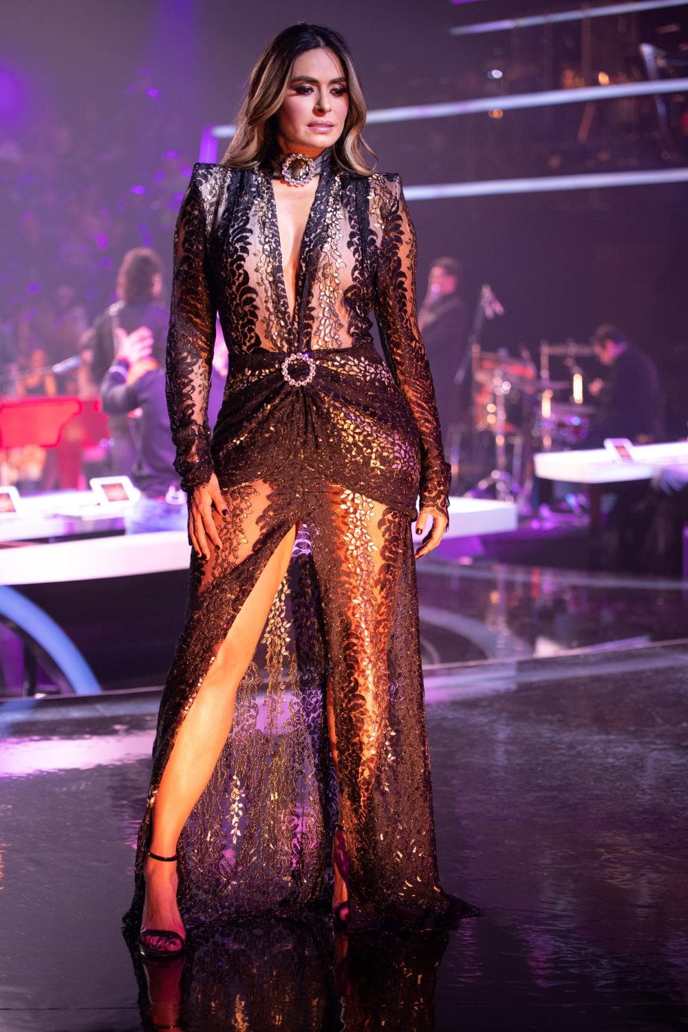 Este largo vestido de encaje en transparencia y encaje, que mezclaba los colores negro y dorado, fue el elegido para cerrar con broche de oro la temporada 2018 del show. La pieza no sólo permitía que Galilea presumiera piernas, escote, cintura y trasero, también la mostraba elegante y llena de estilo. El vestido terminó de fascinarnos por su impresionante escote en V, por su drapeado al frente, por el broche de pedrería que se repetía en el cuello a manera de 'chocker' y por la apertura en la parte inferior que mostraba las piernas de la conductora.