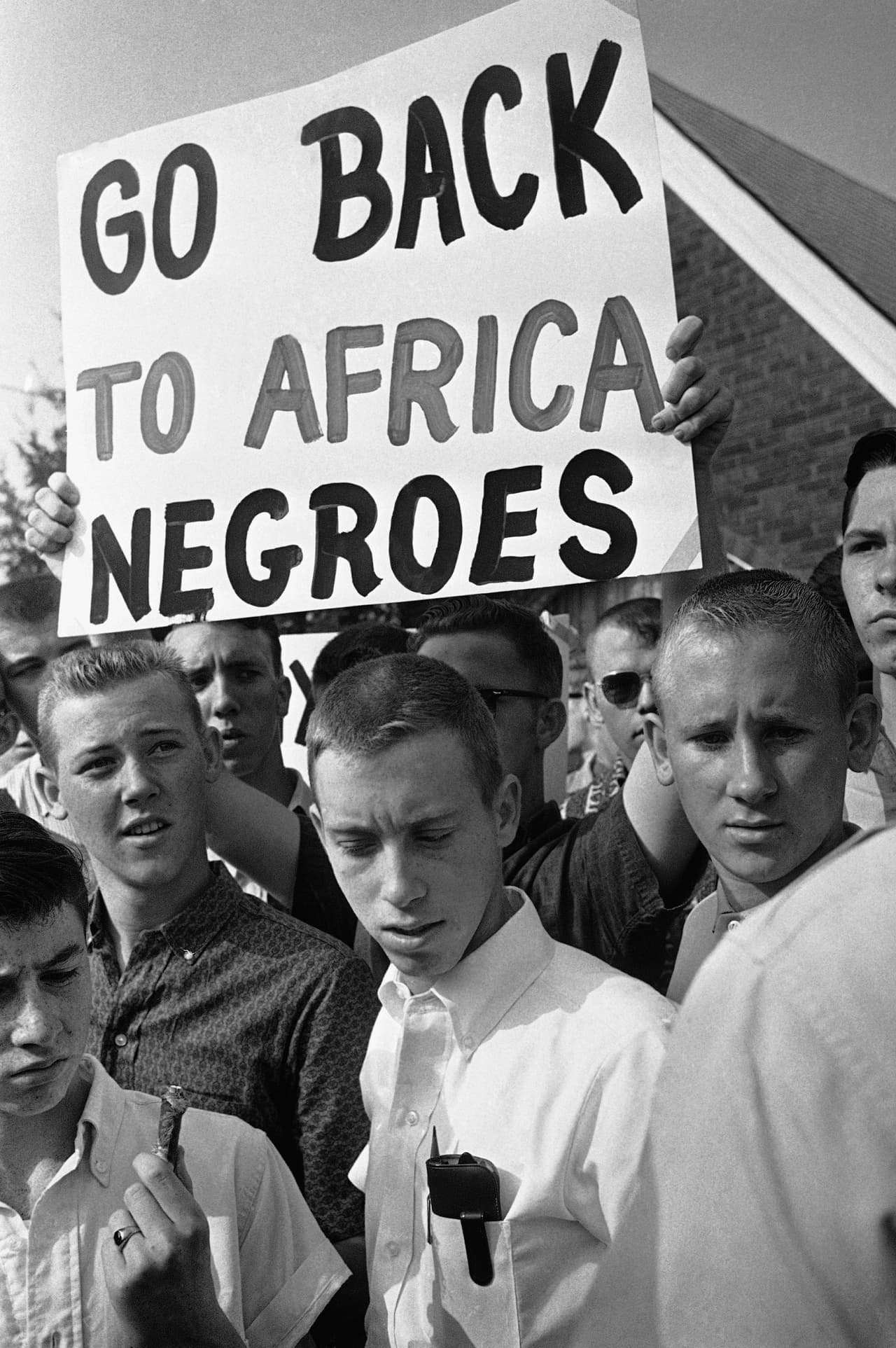 Young male students carrying confederate flags and a sign stage a demonstration across the street from integrated West End High School in Birmingham, Ala., on Sept. 11, 1963. A policeman stands guard. He broke up the demonstration after a short time. (AP Photo)