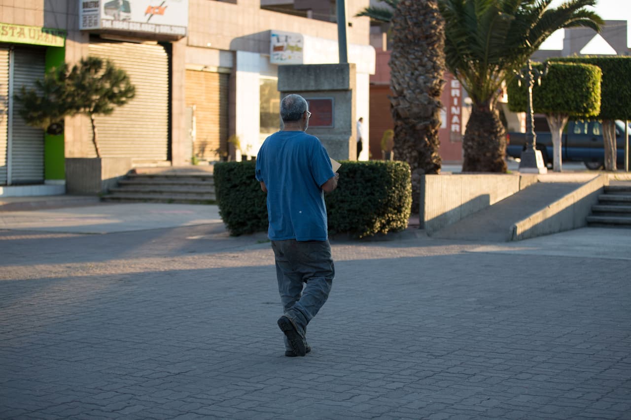 Antonio Martínez-Arreguín, recién deportado, camina en Tijuana. “Ha cambiado mucho… 
<br> Acá hay un puente, se me hace…”, dice. Deambula intentando orientarse: “¡Aquí antes había un McDonalds!”. Para llegar a casa de su primo cruzará una autopista y un río. Tras un mes recuperándose y ahorrando algo de dinero en México, piensa cruzar de nuevo a Estados Unidos. Allí está parte de su familia –y puede ganar $1,000 por semana en vez de $60. Almudena Toral/Univision Digital
<br>