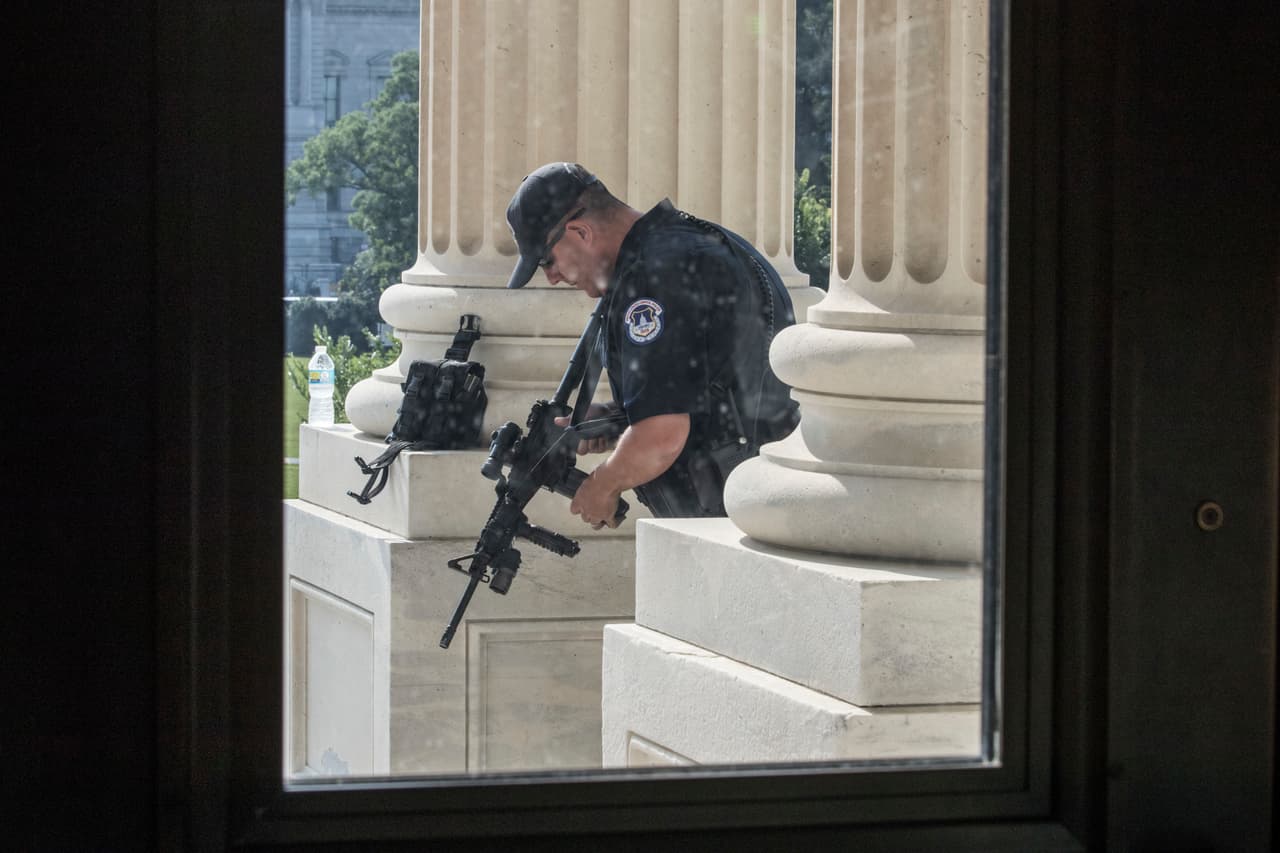 Un policía armado custodia la entrada del Congreso en Washington, luego del incidente en Alexandria.