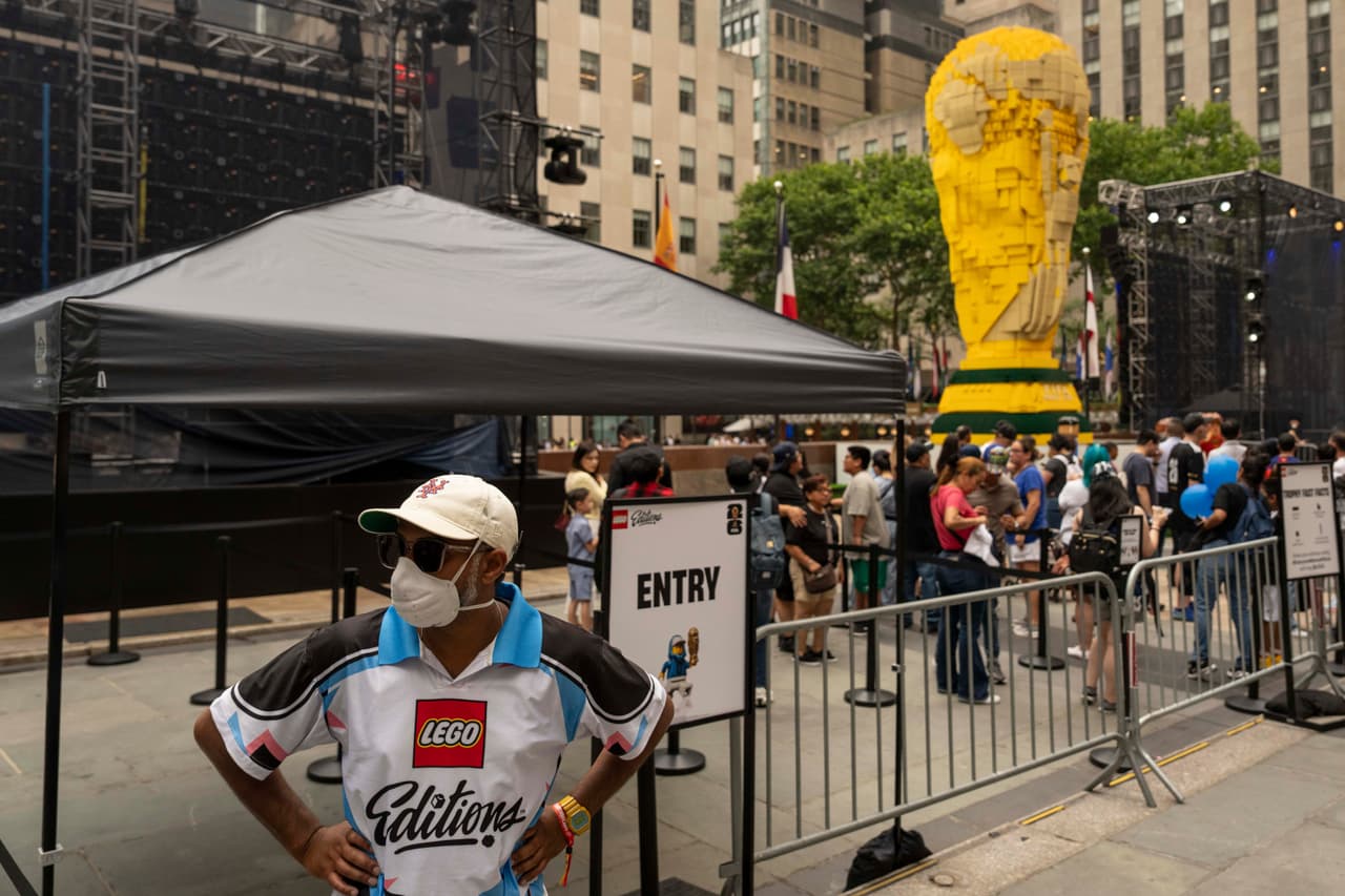 Un voluntario del Mundial lleva una mascarilla mientras el humo de los incendios forestales cubre el cielo en la zona de aficionados del Rockefeller Center, el jueves 16 de julio de 2026, en Nueva York. Los expertos sugieren usar una mascarilla N95 si es necesario estar al aire libre y mantener el aire interior más limpio cerrando las ventanas y usando un purificador de aire o el aire acondicionado.