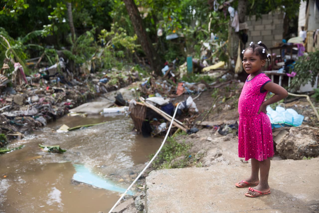 Una niña mira los daños causados por el desbordamiento del río Magua debido a las fuertes lluvias causadas por la tormenta Isaías en la ciudad de Hato Mayor.