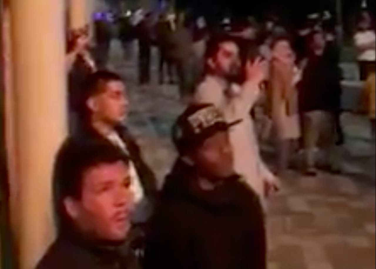 Los vecinos que lograron salir miran desde la calle las labores de los bomberos para sofocar las llamas y sacar a los que están atrapados dentro del edificio.