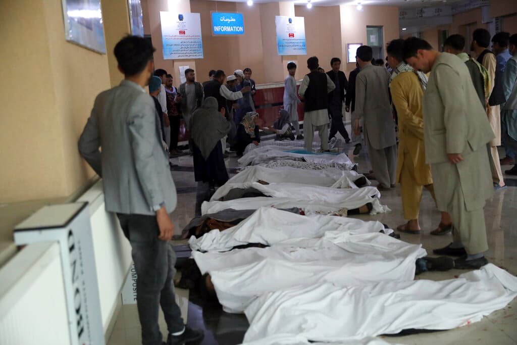 Personas intentan identificar los cuerpos en un hospital tras la explosión de una bomba este sábado en Kabul.