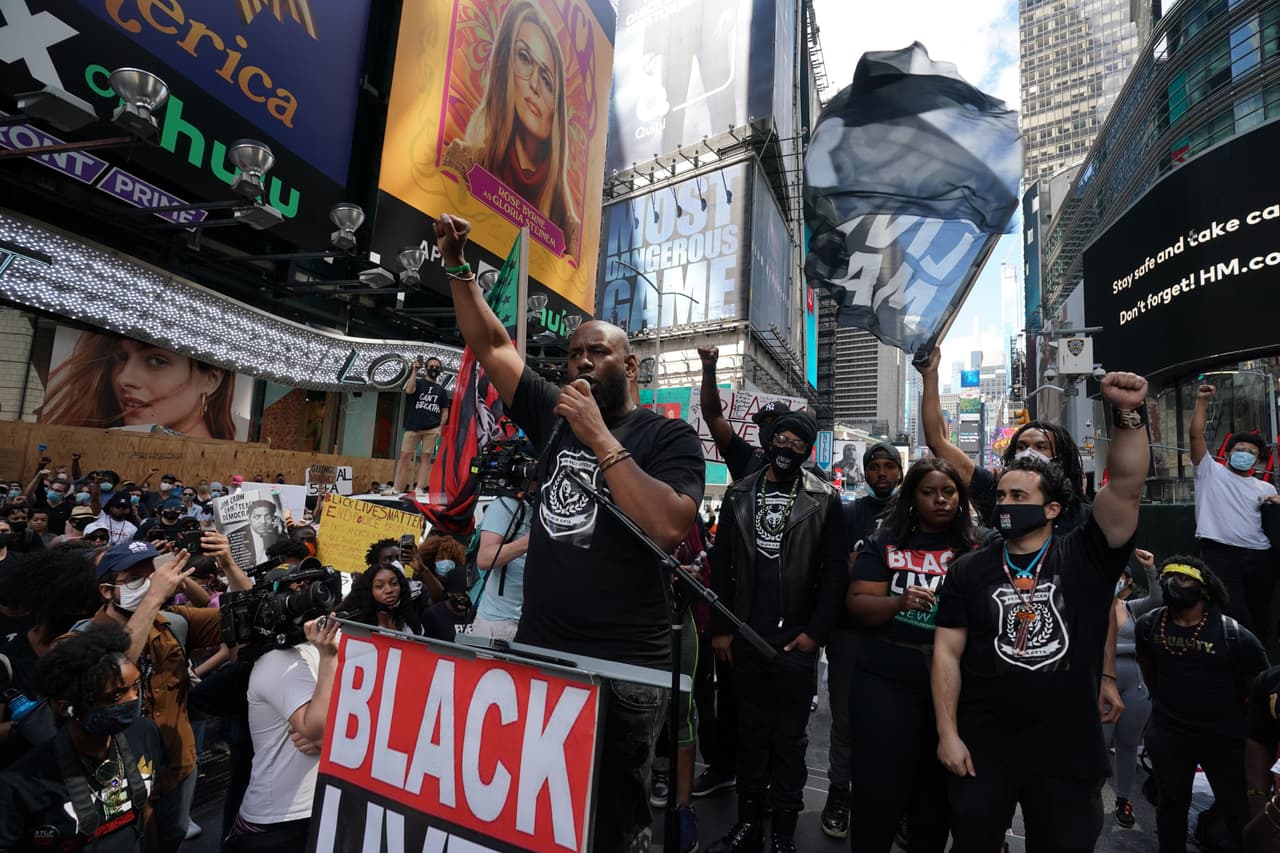 El actor estadounidense Nick Cannon (al fondo y en el centro) escucha a un orador durante una protesta el 7 de junio del 2020. La protesta tuvo lugar un día antes de que Nueva York se dispusiera a iniciar el lunes una "reapertura" económica gradual tras más de dos meses de confinamiento por la pandemia de coronavirus.