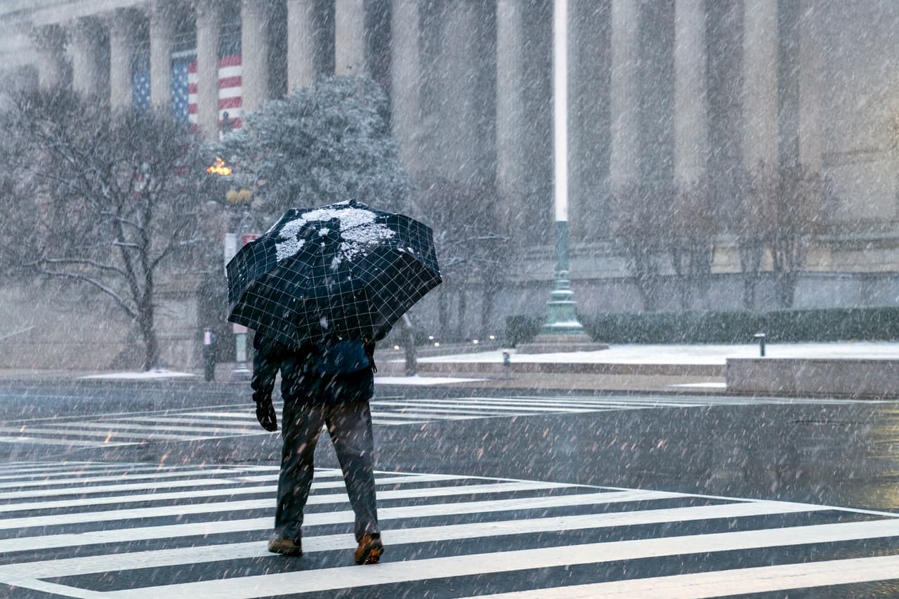 Un hombre en Constitution Avenue cerca de los Archivos Nacionales. Muchas escuelas y oficinas permanecerán cerradas porque toda la región de DC se prepara para la severa tormenta de invierno.