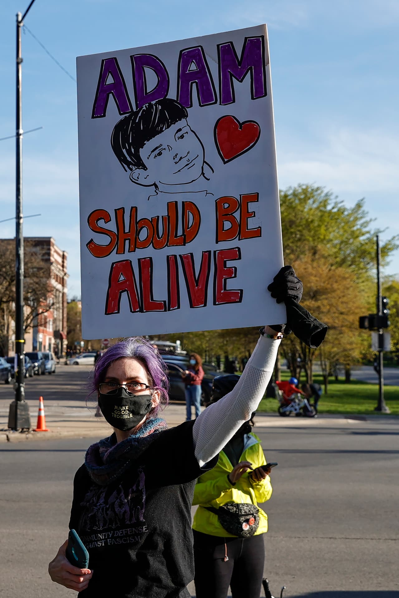 Esta mujer sostiene una cartel en la manifestación realizada en el vecindario de Logan Square, Chicago, por la muerte de Adam Toledo a manos de la policía.