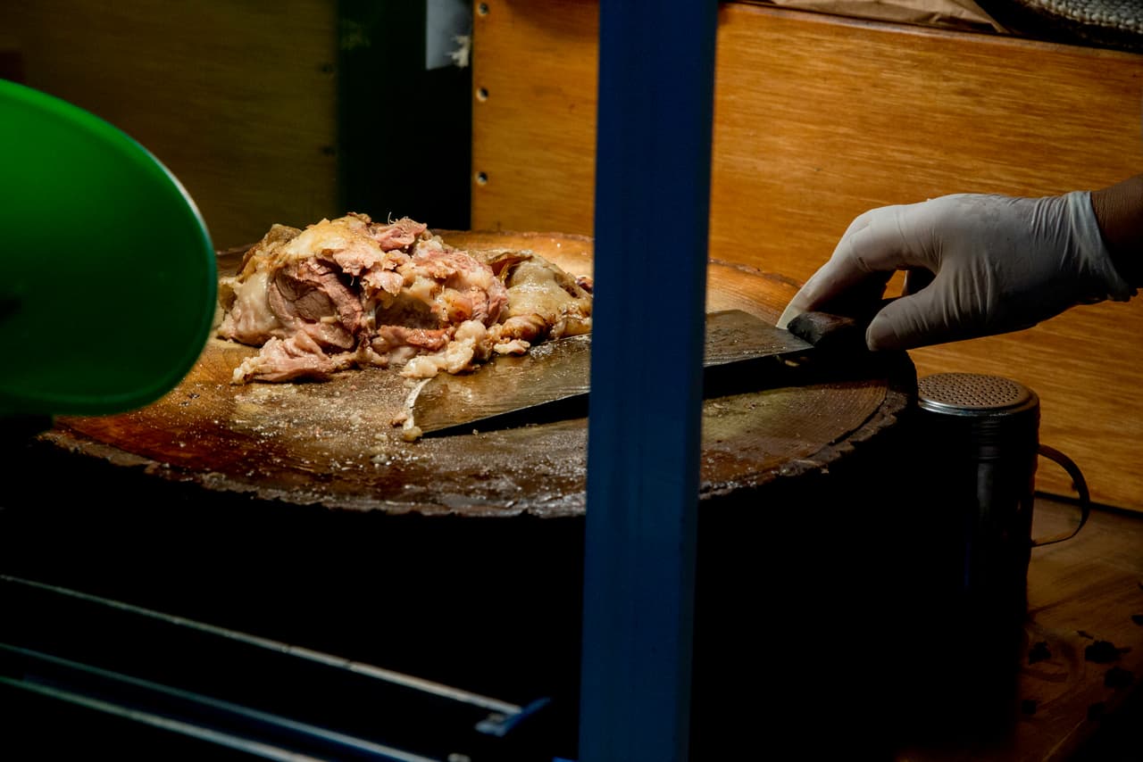 Despachar barbacoa en la vitrina a la usanza mexicana es casi un ritual. En él se van sacando poco a poco los trozos de carne, aún calientes, de las pencas de maguey con que los envuelven para su cocción. Después, bajo los focos calefactores se pica la carne sobre un tronco de madera natural y se sirve directamente sobre la tortilla.