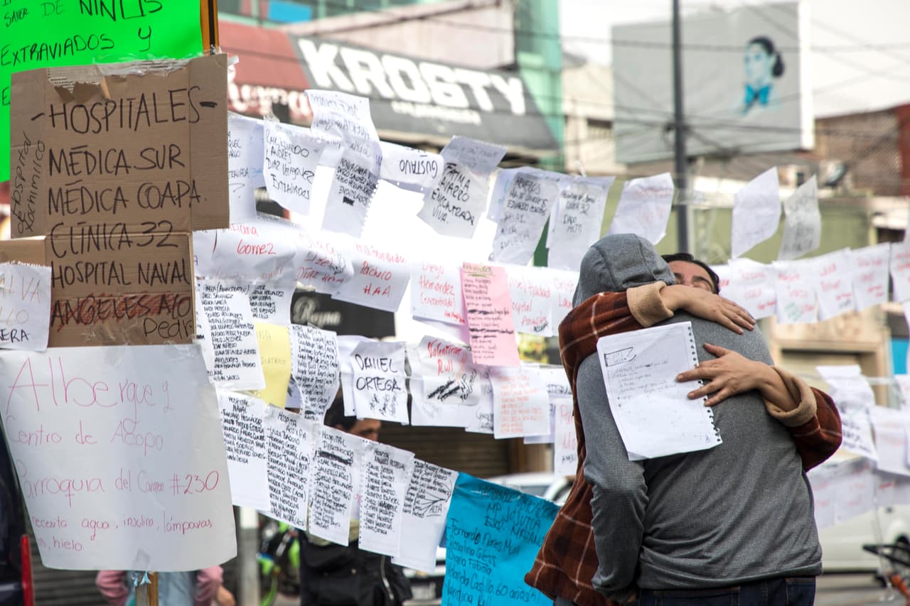 Familiares de los alumnos de la escuela Enrique Rébsamen revisan las listas colocadas cerca de la escuela colapsada. Allí pueden conocer el paradero de sus seres queridos si ya han sido rescatados.