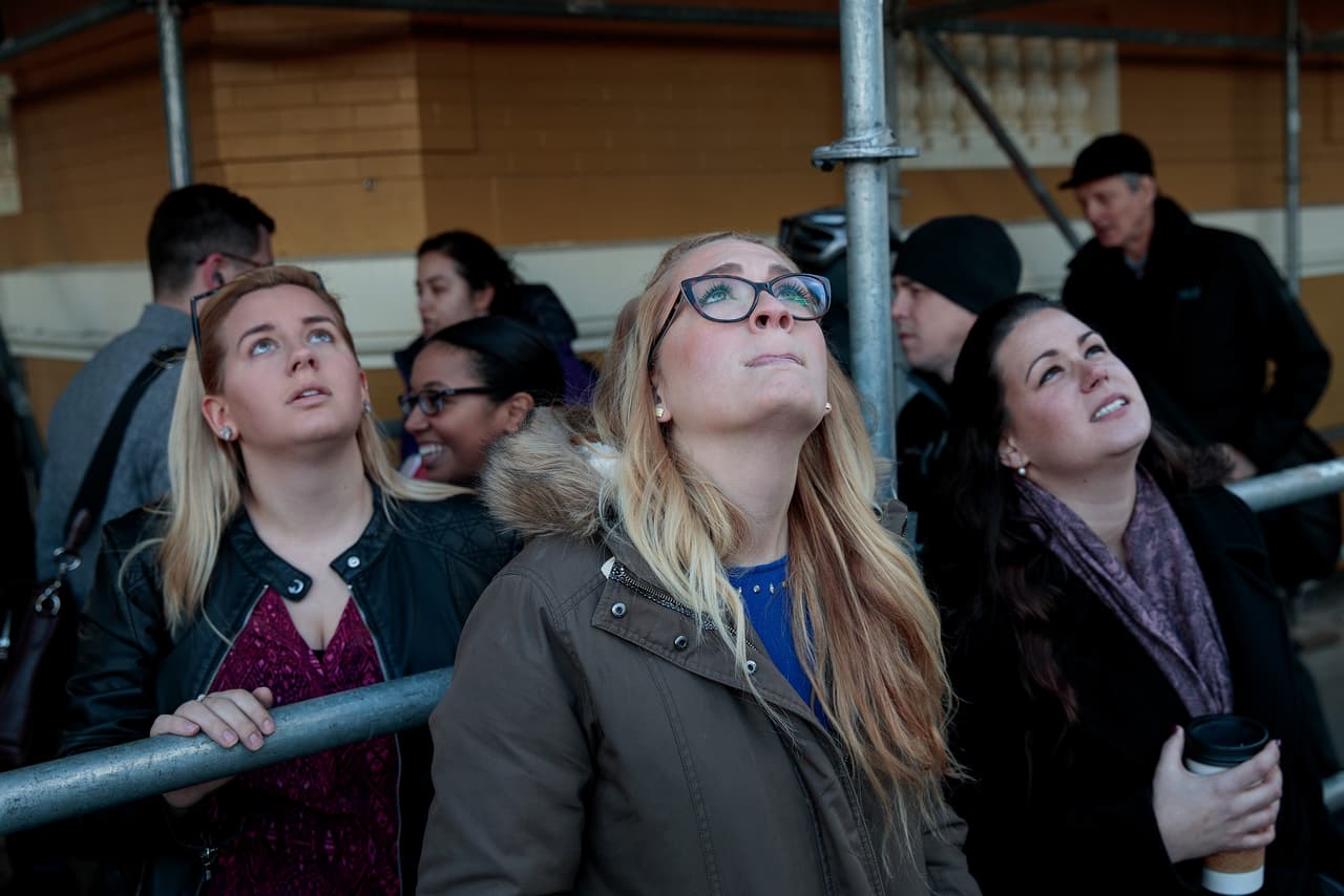 Peatones se detienen a observar a los manifestantes de Greenpeace mientras cuelgan la bandera de la grúa.