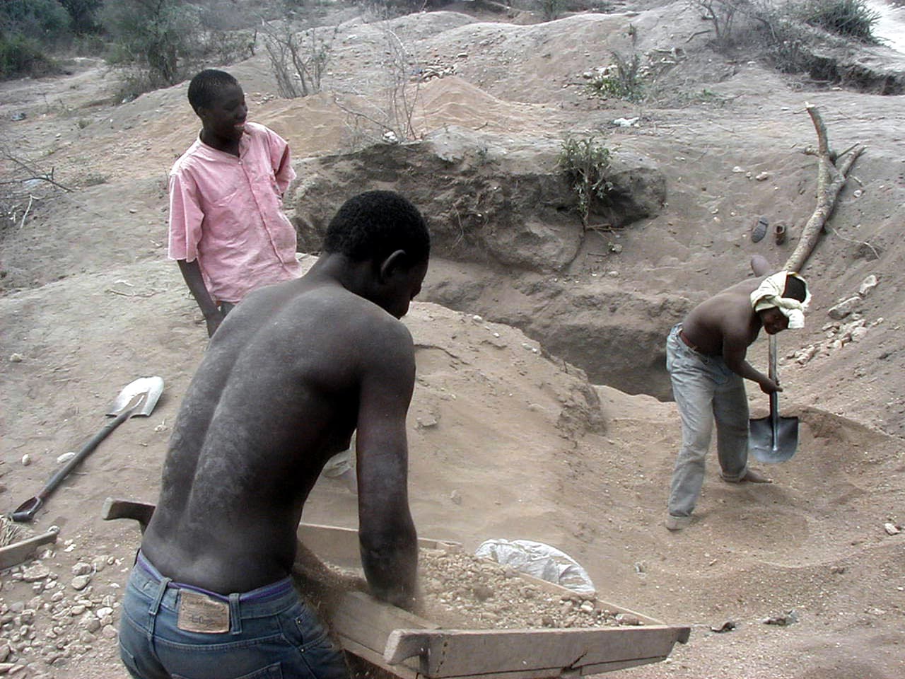 Mineros en busca de tanzanita en 2001. En 2018, cuando el ejército comenzó a construir un muro de 15 millas alrededor de las minas de Mererani, el presidente de tanzania estimó el 40% de la producción de la piedra se perdía en el contrabando.
<br>