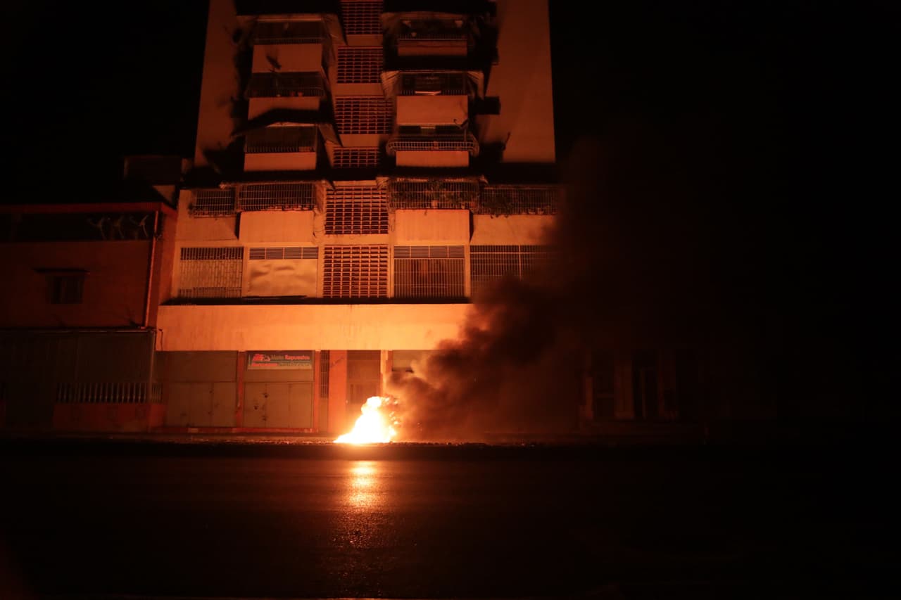 Un pequeño fuego ilumina una calle de Caracas en la noche del jueves. “Hoy declaran que el apagón, de más de 15 horas, es producto de un saboteo externo. 
<b>Saboteo es la corrupción, saboteo es que no permitieron elecciones, saboteo es que bloquearon la entrada de comida y medicinas”,</b> escribió en su cuenta de Twitter el presidente de la Asamblea Nacional Juan Guaidó, reconocido por más de 50 países como el presidente encargado de Venezuela.