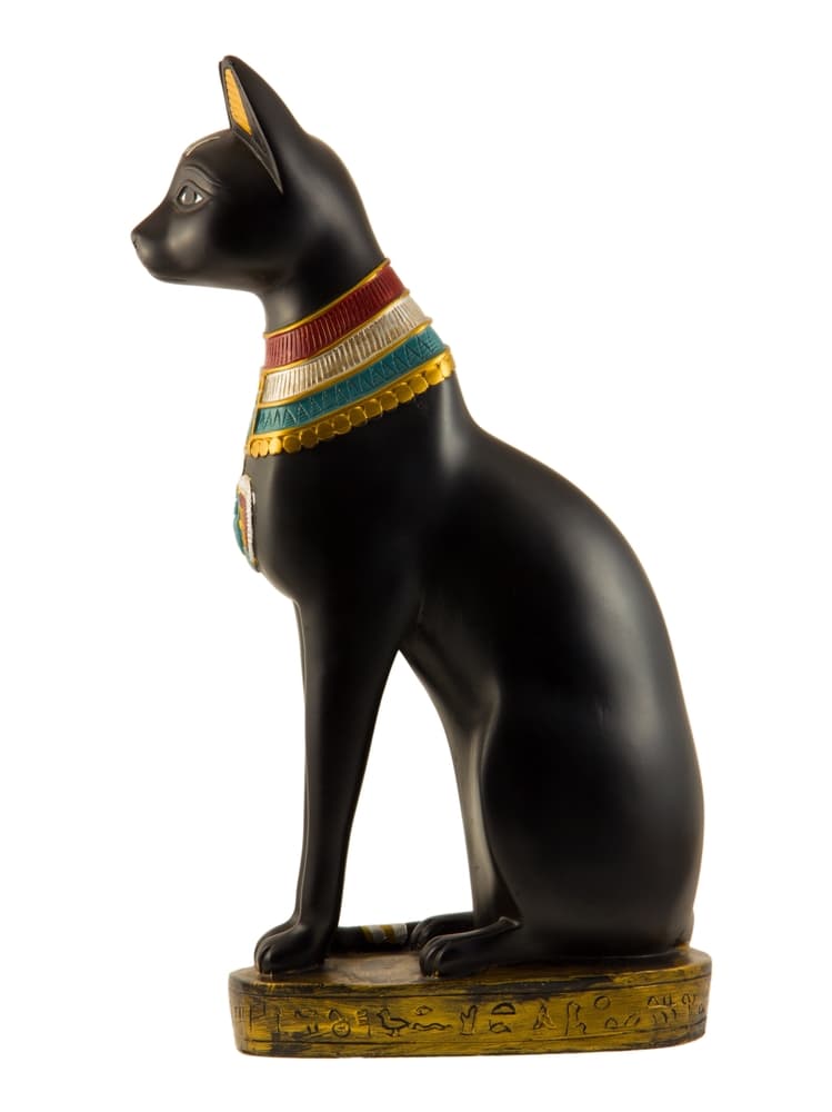 Anubis también es esencial en la cultura egipcia. Como el dios del otro mundo, representa el más allá, el camino detrás de la muerte, simbolizado en adornos como gatos o en su forma humana con cabeza de animal, como amuleto para protección y reforzar el poder.