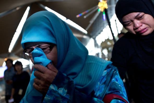 Familiares de los pasajeros del Malaysia Airlines vuelo MH17 lloran ante la tragedia.