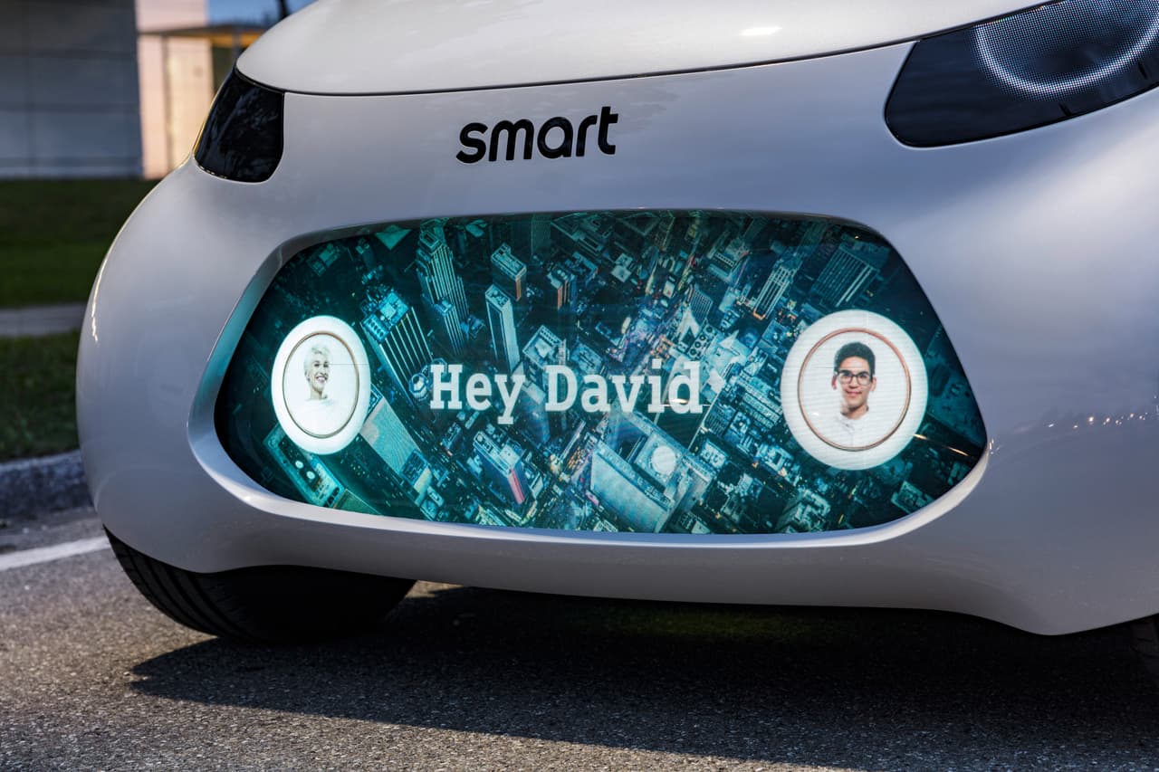 Aquí la pantalla en el panel frontal del Smart Vision EQ Fortwo está
<b>saludando</b> a David, el pasajero que ha llegado a recoger.