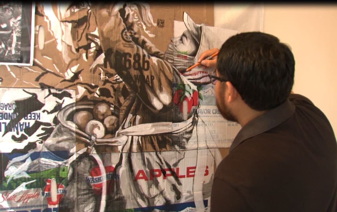 Su lienzo son las cajas que donan sus amigos que trabajan en la pizca.