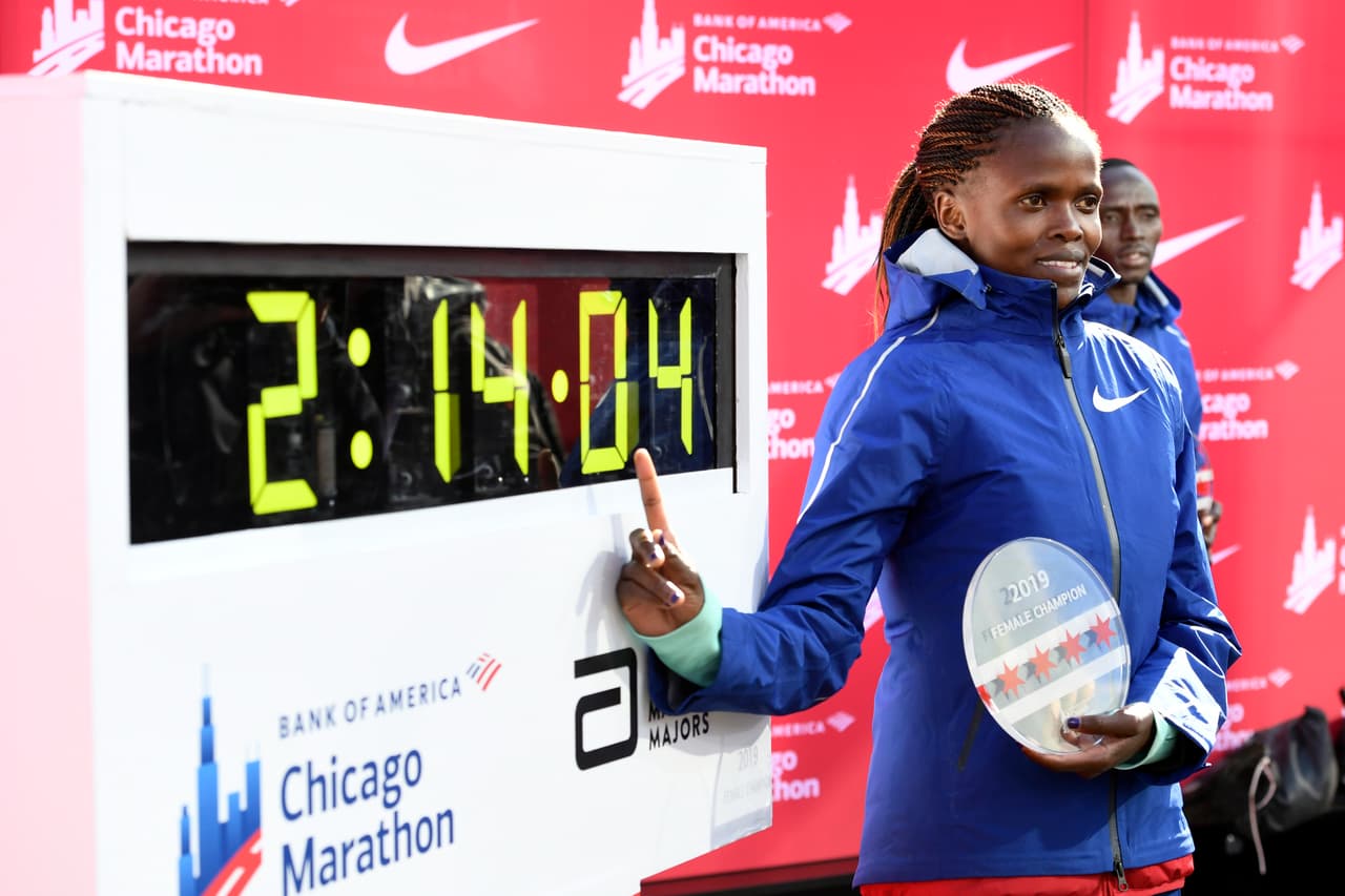 Brigid Kosgei, de Kenia, posa con su tiempo luego de ganar la rama femenil del Maratón de Chicago y establecer un récord mundial con 2:14:04, el domingo 13 de octubre de 2019, en Chicago.