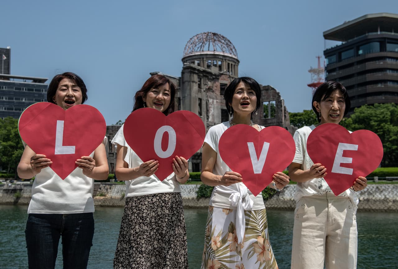 Algunos sobrevivientes, sus parientes y otras personas conmemoraron el aniversario de la explosión
<b> </b>a las 8:15 a.m. de este jueves con el sonido de una campana, seguido por un minuto de silencio, en el Parque Conmemorativo de la Paz.
<br>
<br>Mujeres sostienen tarjetas en forma de corazón donde se puede leer la palabra amor mientras cantan cerca de la Cúpula de la Bomba Atómica.