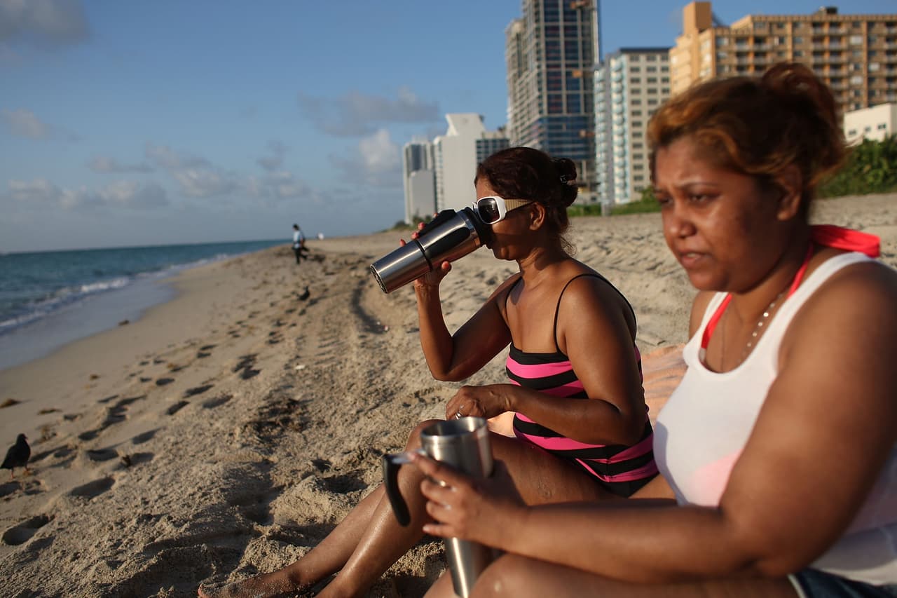 Según informó el Servicio Meteorológico Nacional (NWS), el calor se insensitifcará durante esta temporada en los condados de Miami-Dade, Broward y Monroe. En la foto, Asha Shaw y su hija Amanda Shaw beben agua mientras se oculta el sol.