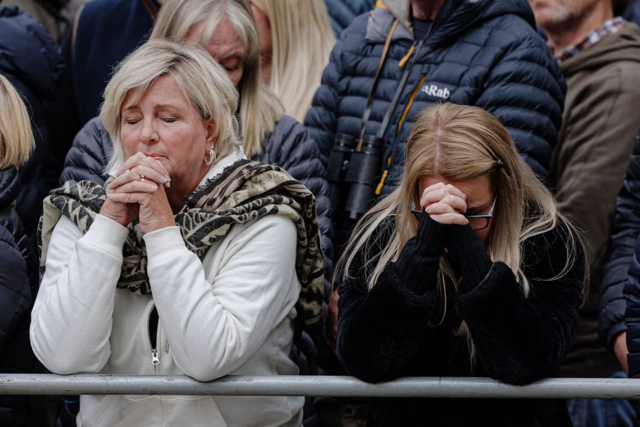 Dos mujeres rezan por la reina Isabel II durante su funeral en Londres.