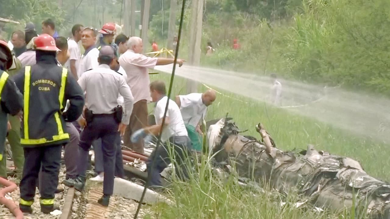 Bomberos intentan enfriar una de las partes del avión que quedó en la zona boscosa.