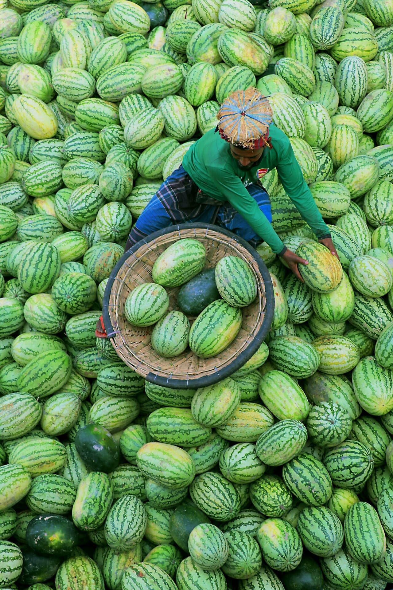 <b>‘Un hombre en los melones’, </b>tomada en Dhaka, Bangladesh. “Durante la temporada de sandías el mercado mayorista reúne a vendedores de todo el país. Transportan su mercancía en barco, al igual que el vendedor en esta foto”, dijo el fotógrafo.