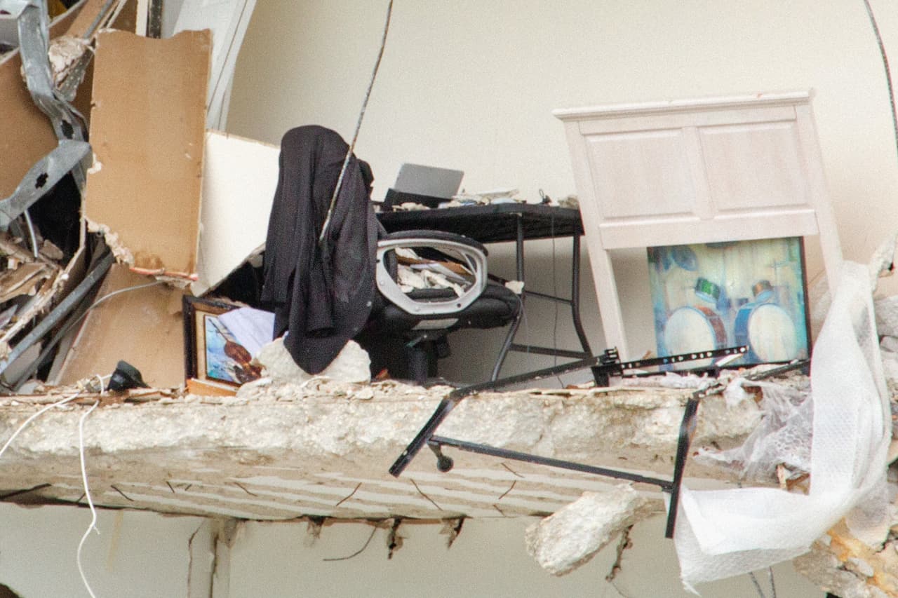 Un espacio de oficina en el piso 11 del edificio. Todavía sobre el escritorio una computadora abierta, un saco colgado en la silla de trabajo y en el suelo dos cuadros con imágenes de instrumentos musicales.
<br>
<br>Desde la distancia esta tragedia parece absurda, especialmente cuando vemos alrededor a decenas de edificios muy parecidos en altura y edad intactos frente al mar.
<br>