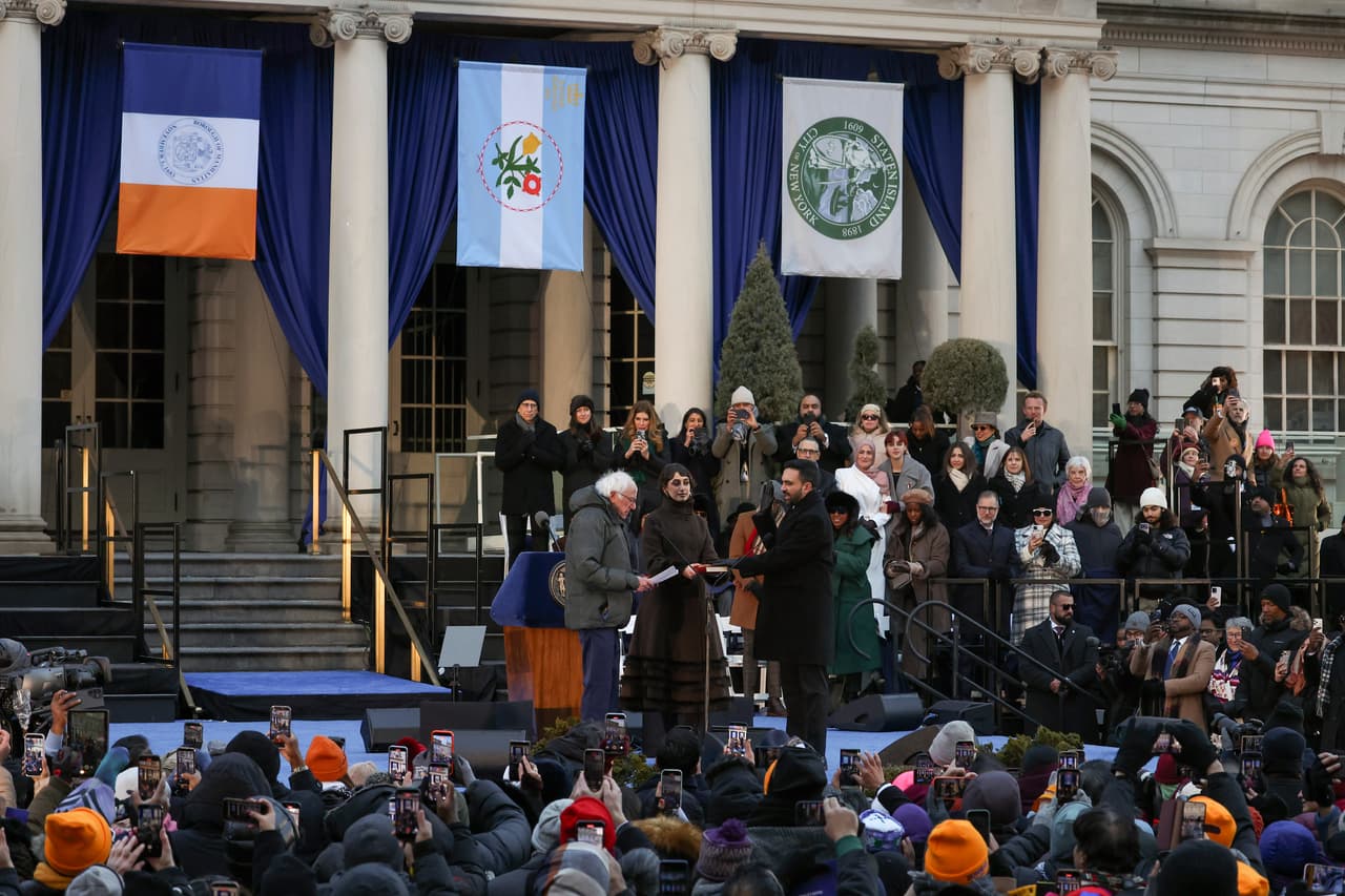<b>Zohran Mamdani juró como alcalde de Nueva York</b> con su esposa Rama Duwaji sosteniendo el Corán, a voz de 
<br>Bernie Sanders y frente a una multitud de simpatizantes en City Hall Plaza este 1 de enero del 2026.
<br>
<br>En la madrugada, apenas a las 12:01 lo había hecho de forma oficial en 
<a href="https://www.univision.com/local/nueva-york-wxtv/politica-new-york/zohran-mamdani-alcalde-nueva-york-ceremonia-metro-old-city-hall-2026" target="_blank">una ceremonia privada en Old City Hall</a>.