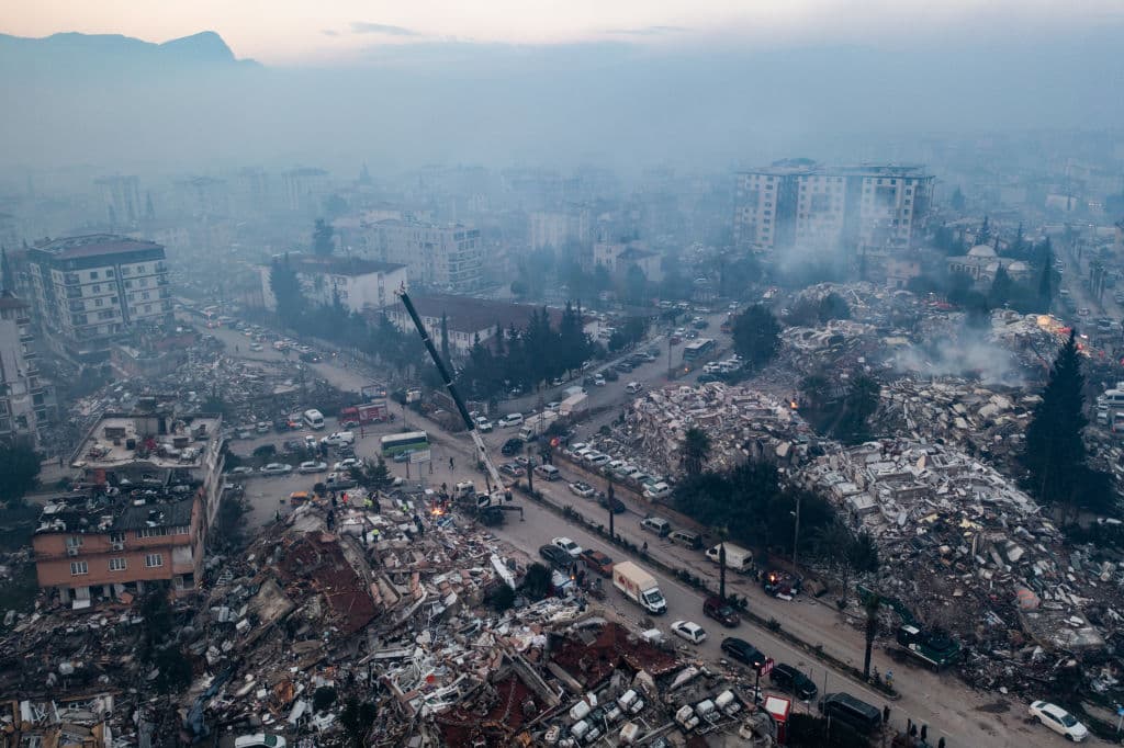 Una vista aérea muestra humo saliendo de edificios derrumbados el 08 de febrero 2023 en Hatay, Turquía. El presidente turco, Recep Tayyip Erdogan, dijo que13 millones de los 85 millones de habitantes del país quedaron damnificadosy declaró el estado de emergencia en 10 provincias. Señaló que alrededor de 380,000 personas se han refugiado en albergues u hoteles gubernamentales.