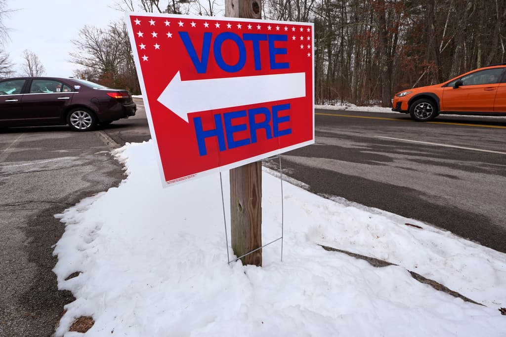 Una señal enterrada en nieve indica el camino a un centro de votación en la ciudad de Auburn, en New Hampshire.