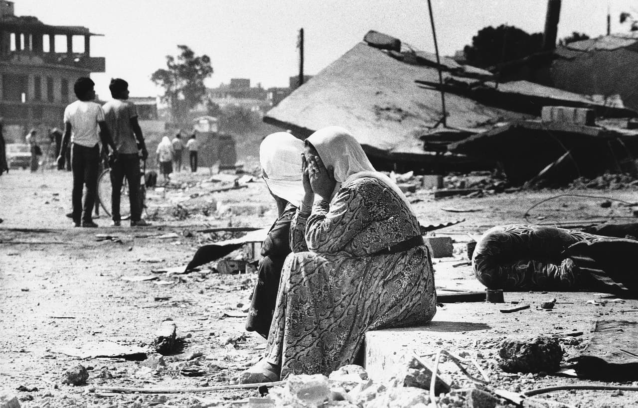 Foto de archivo: dos palestinas lloran en el campo de refugiados en Beirut, Líbano, el 19 de septiembre de 1982 tras hallar los cuerpos de familiares asesinados por militantes de extrema derecha.