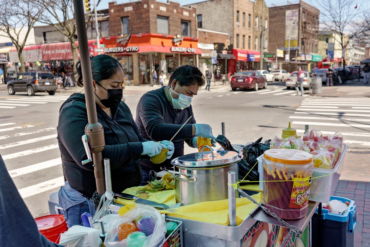 Ruth Palacios y Arturo Xelo, un matrimonio de México, trabajan en su puesto de frutas en el barrio Corona del distrito Queens de Nueva York, el martes 13 de abril de 2021.