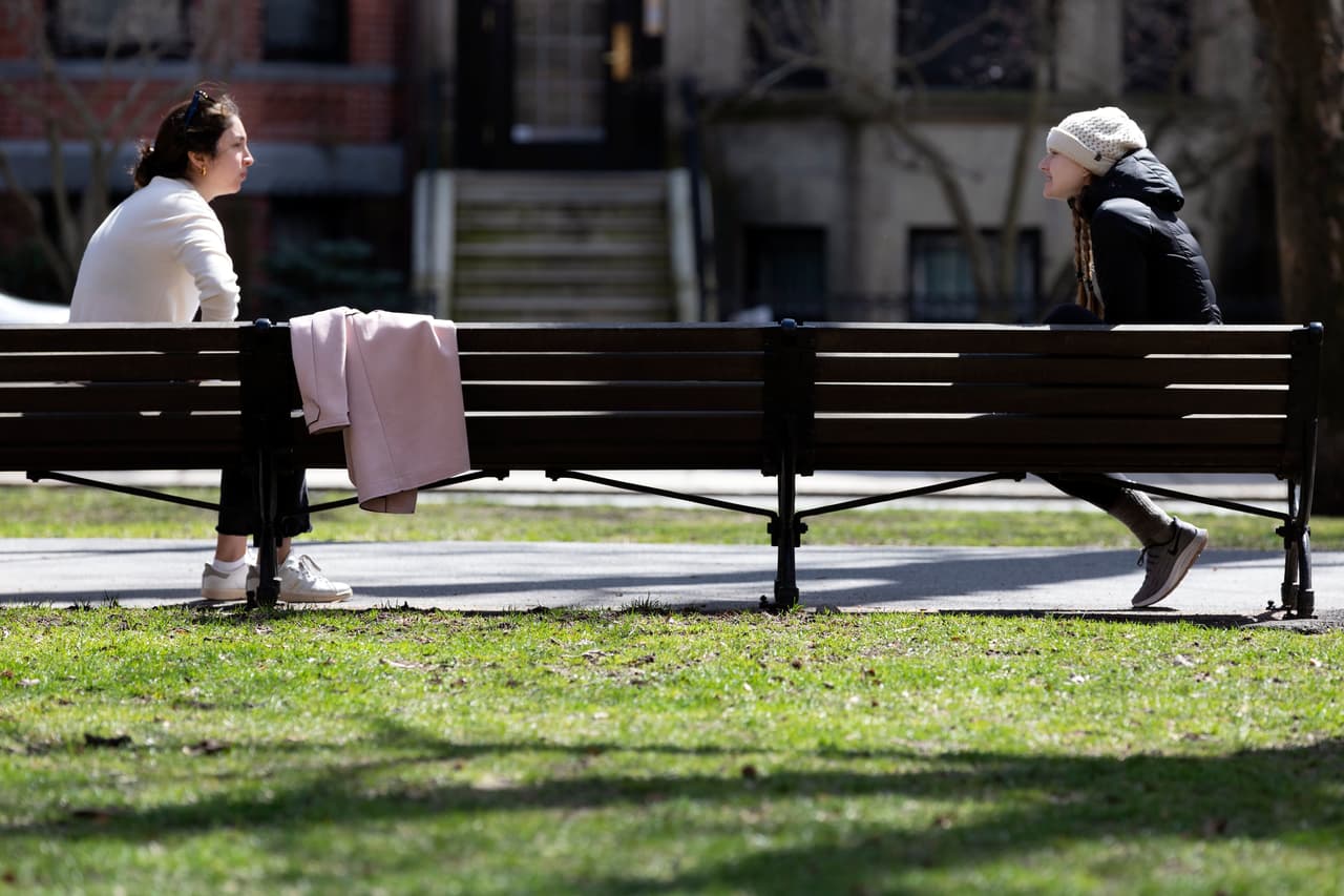 <b>Guardando distancia.</b> Dos mujeres conversan con los seis pies de separación recomendados en un banco de una calle de Boston, Massachusetts. 4 de abril.
<br>