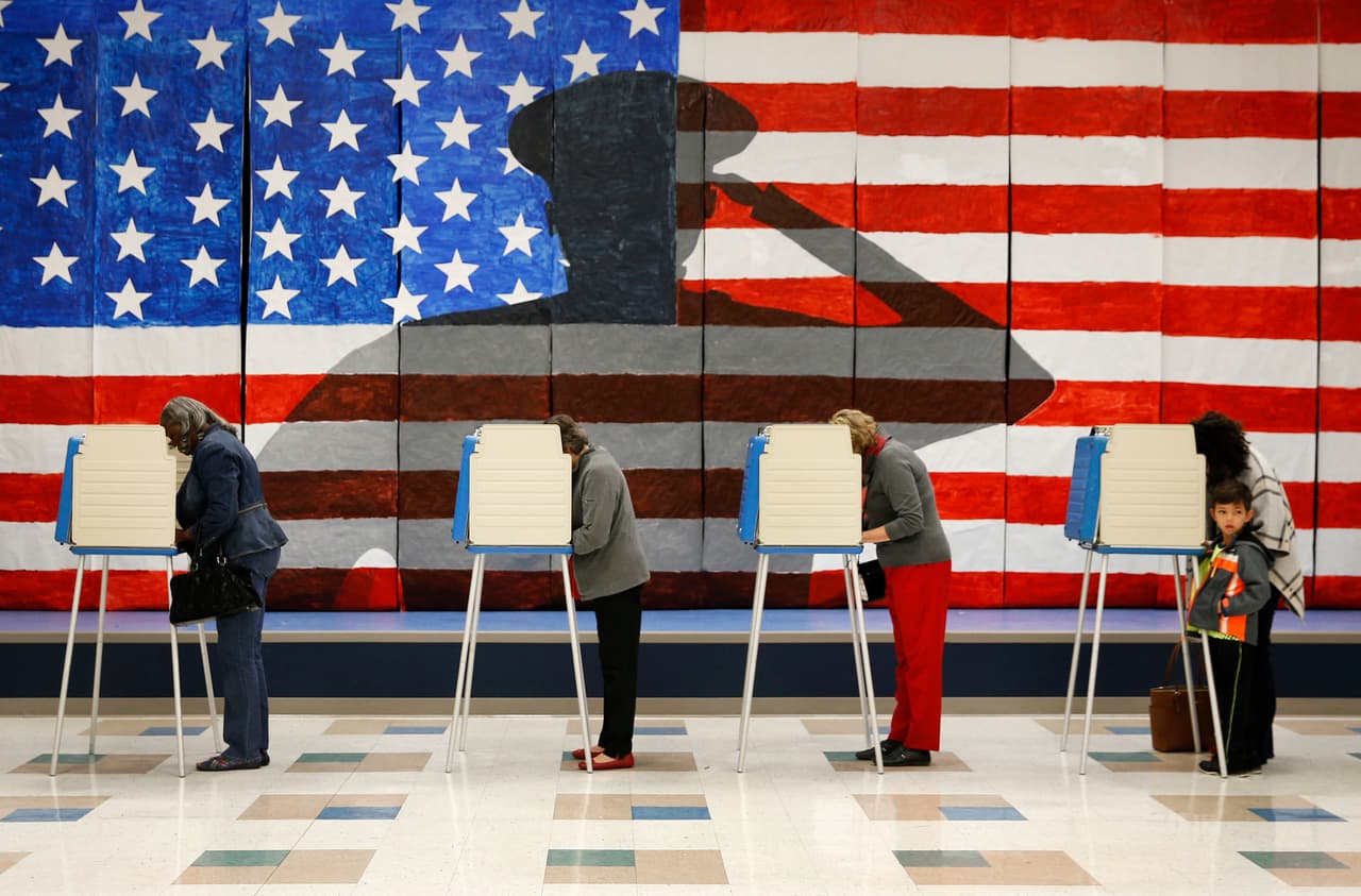 Voters line up in voting booths to cast their ballots at Robious Elementary School in Richmond, Va. on Tuesday, Nov. 8, 2016. The 30-ft. x 12-ft. image in the background was painted by 3rd and 4th graders at the school in preparation for Veterans Day. (Shelby Lum/Richmond Times-Dispatch via AP)