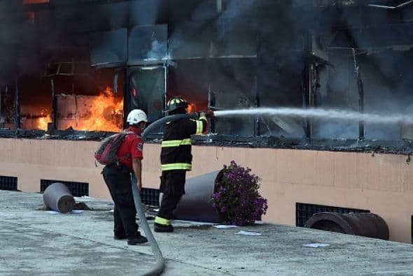 Algunos bomberos trataban de apagar el fuego.
